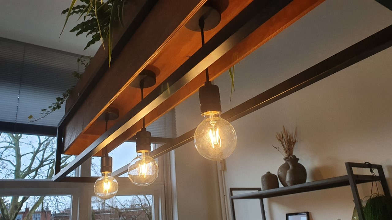 Close-up of the three warm filament bulbs hanging beneath the wooden trough