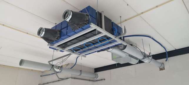 ICECUBE climate system installed against a ceiling, with ducting and piping
