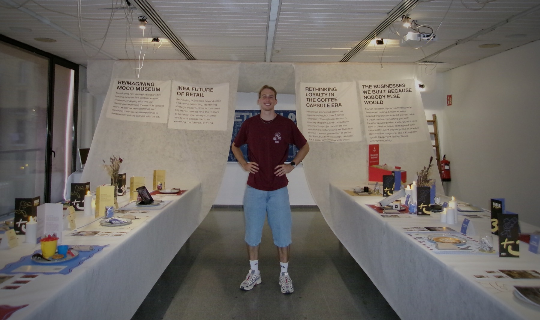Roan standing between the two Table+34 tables in the finished exhibition room